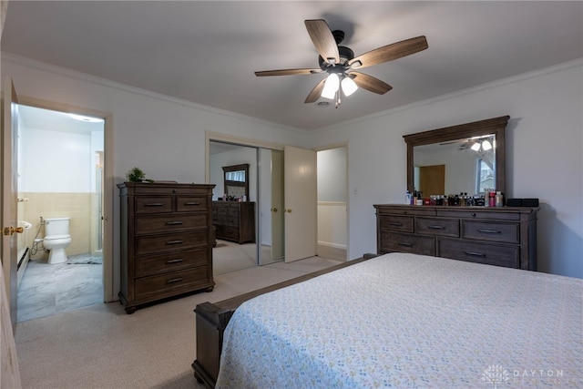 bedroom with a closet, ornamental molding, connected bathroom, light carpet, and ceiling fan