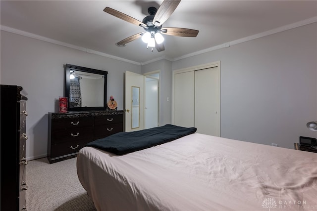 carpeted bedroom with ornamental molding, ceiling fan, and a closet