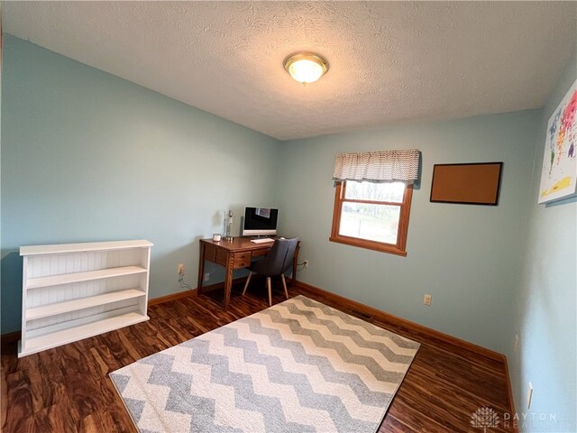 home office with a textured ceiling, wood finished floors, and baseboards