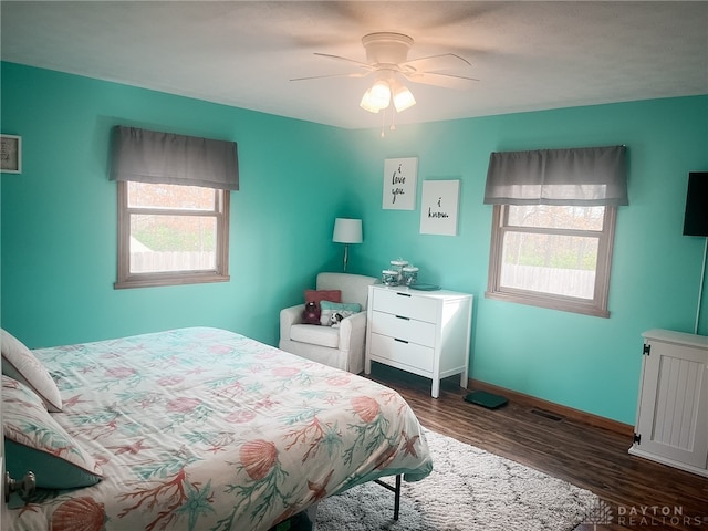 bedroom with baseboards, visible vents, ceiling fan, and dark wood-type flooring