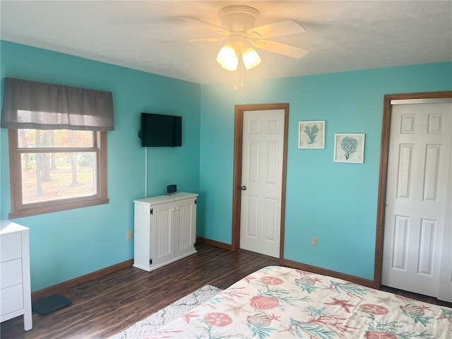 bedroom with dark wood-style flooring, ceiling fan, and baseboards