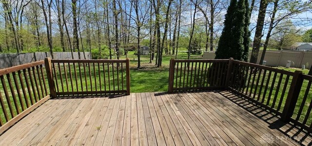 deck with a lawn and a fenced backyard