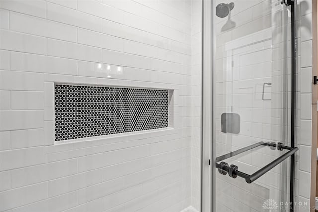 bathroom with a shower with door