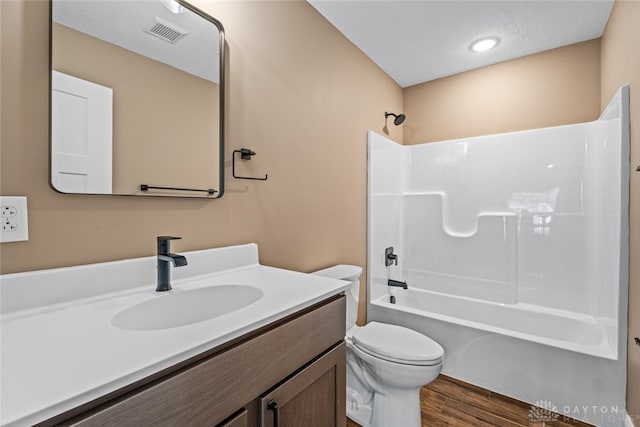 full bathroom featuring hardwood / wood-style floors, vanity, toilet, and bathing tub / shower combination