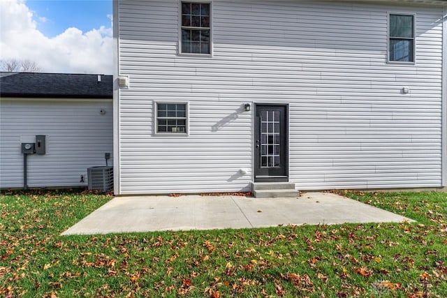 rear view of property featuring a patio, central AC unit, and a lawn