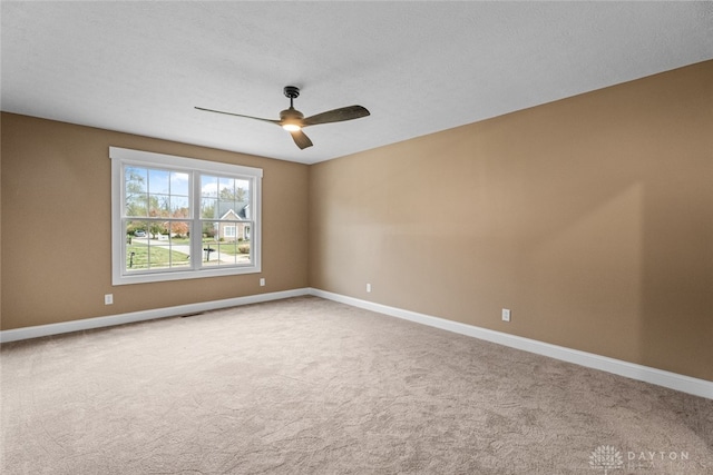 spare room featuring light carpet, a textured ceiling, and ceiling fan