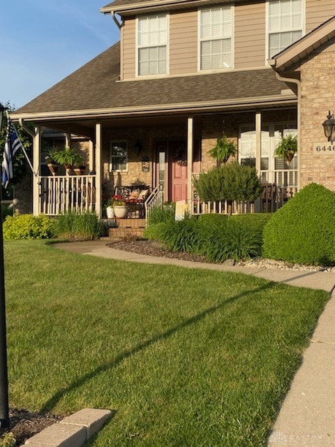 exterior space featuring covered porch and a front yard