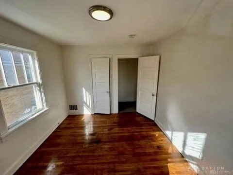 unfurnished bedroom with dark hardwood / wood-style floors