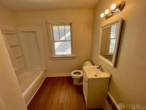 bathroom with toilet, vanity, and hardwood / wood-style flooring