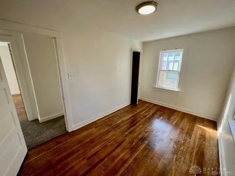 empty room with dark wood-type flooring