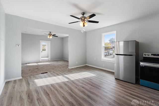 interior space with ceiling fan, plenty of natural light, light hardwood / wood-style flooring, and appliances with stainless steel finishes