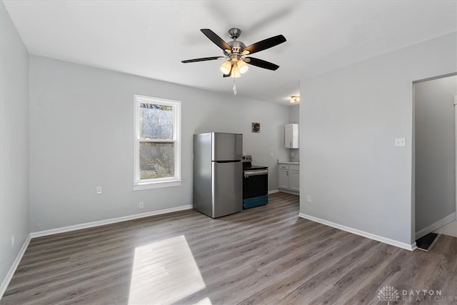 unfurnished living room featuring ceiling fan and light wood-type flooring