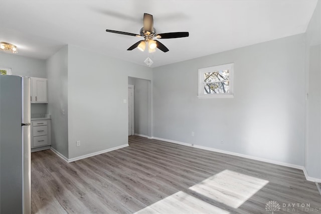 empty room with ceiling fan and light wood-type flooring