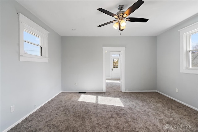 unfurnished room with carpet flooring and plenty of natural light