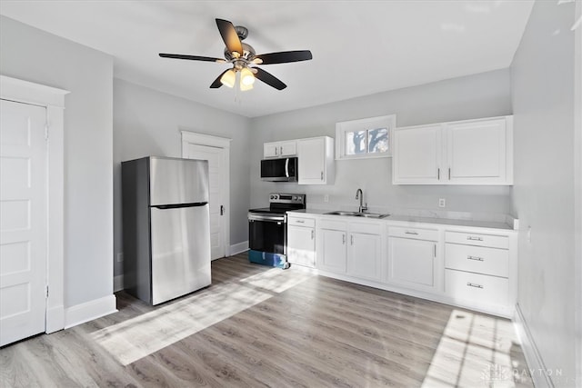 kitchen featuring white cabinetry, appliances with stainless steel finishes, sink, and light hardwood / wood-style flooring