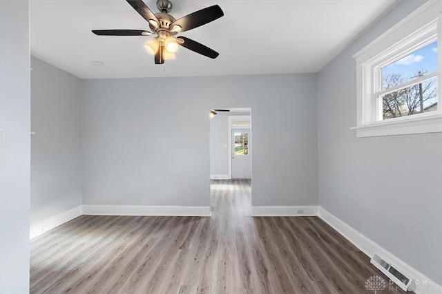 spare room with hardwood / wood-style flooring, a healthy amount of sunlight, and ceiling fan