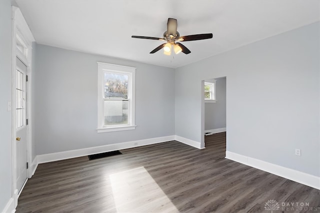 empty room featuring dark wood-type flooring and ceiling fan