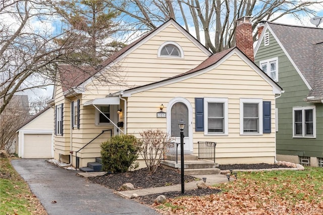 view of front of home with a garage and an outbuilding