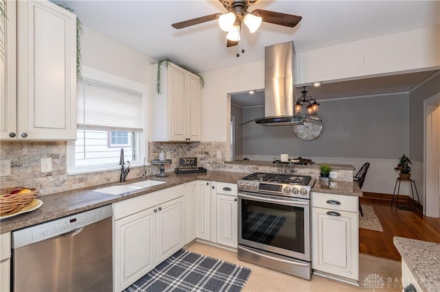 kitchen with island exhaust hood, appliances with stainless steel finishes, white cabinetry, and sink