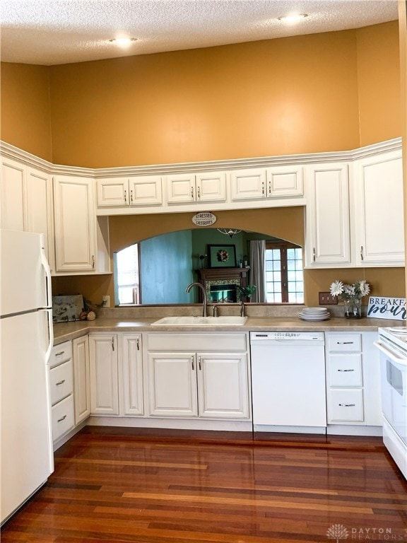 kitchen with a wealth of natural light, sink, dark hardwood / wood-style flooring, white appliances, and white cabinets