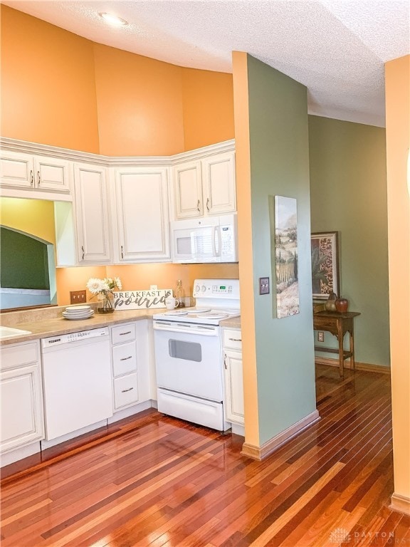 kitchen with white appliances, a high ceiling, light hardwood / wood-style flooring, a textured ceiling, and white cabinetry