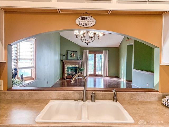 kitchen with sink, lofted ceiling, and an inviting chandelier