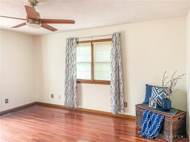 spare room featuring wood-type flooring, a textured ceiling, and ceiling fan