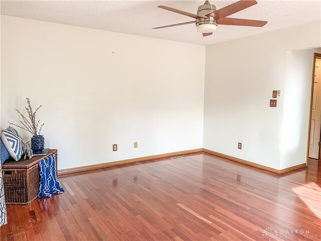 spare room featuring a textured ceiling, hardwood / wood-style flooring, and ceiling fan