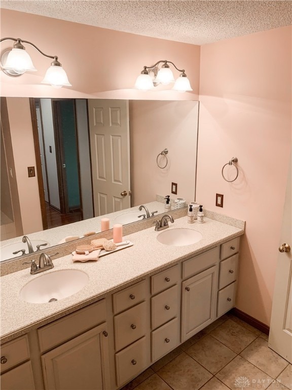 bathroom with tile patterned flooring, vanity, and a textured ceiling