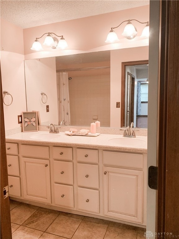 bathroom featuring tile patterned flooring, vanity, curtained shower, and a textured ceiling