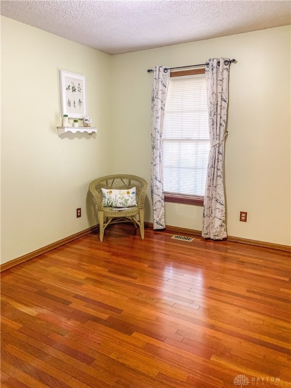 unfurnished room featuring hardwood / wood-style floors and a textured ceiling