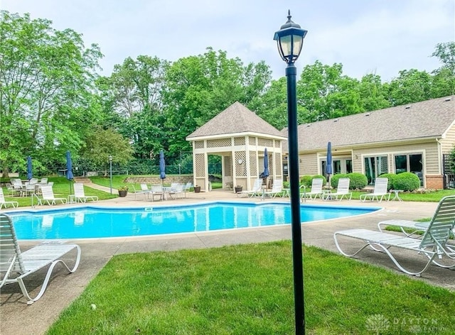 view of swimming pool with a lawn and a patio