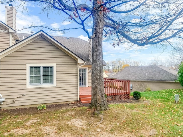 view of property exterior with a yard and a wooden deck