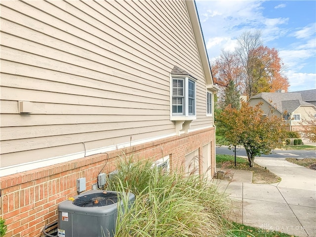 view of side of home with a garage and central AC