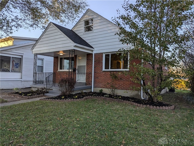 bungalow featuring covered porch and a front lawn