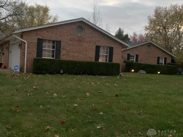 view of property exterior featuring a lawn and a garage