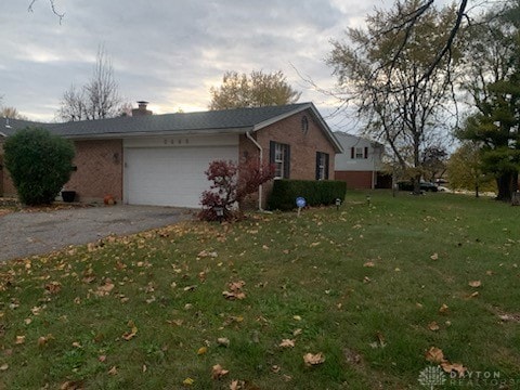 single story home with a lawn and a garage