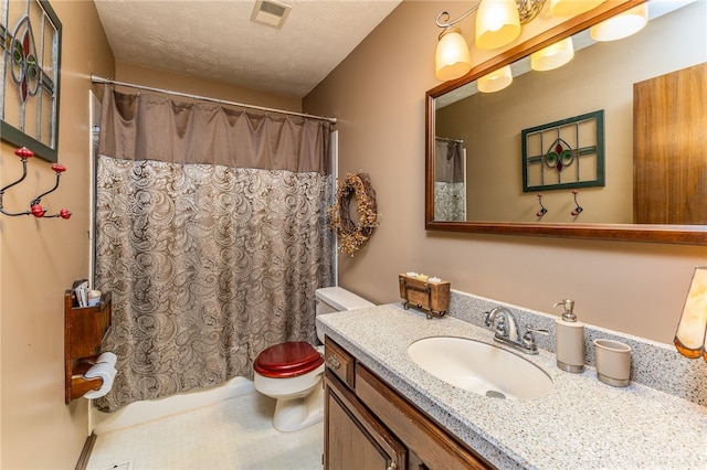 bathroom with vanity, toilet, and a textured ceiling