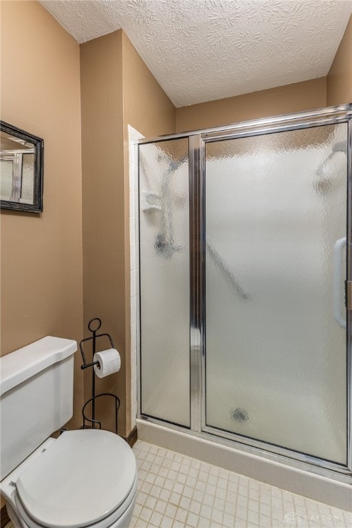 bathroom featuring a shower with door and a textured ceiling