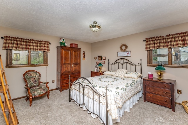 bedroom with light carpet, a textured ceiling, and multiple windows