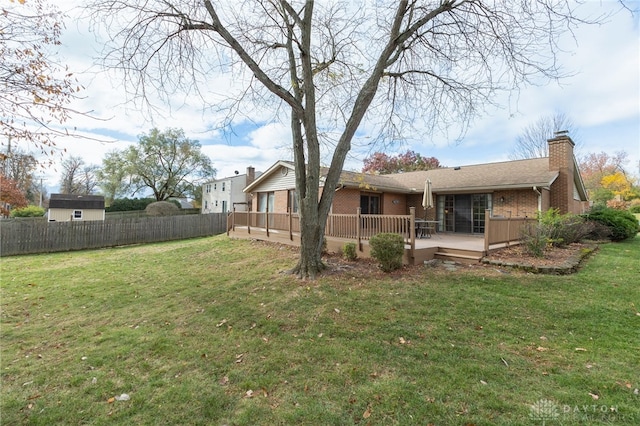 back of house featuring a yard and a wooden deck