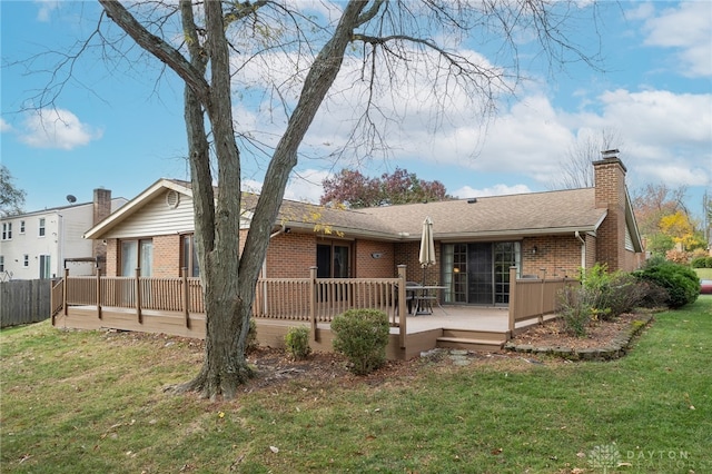 back of property featuring a lawn and a deck