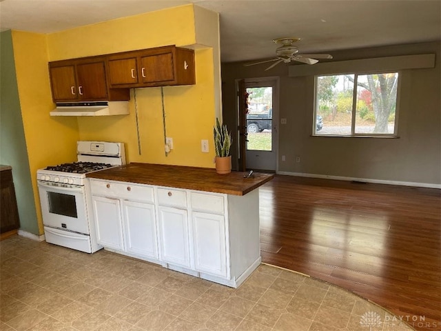 kitchen featuring white gas range oven, light hardwood / wood-style flooring, and ceiling fan