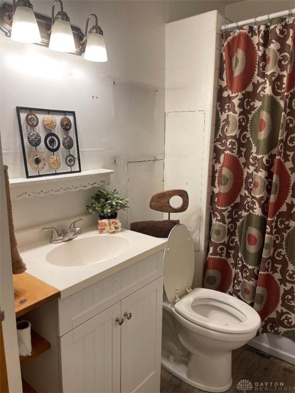 bathroom featuring vanity, toilet, and curtained shower