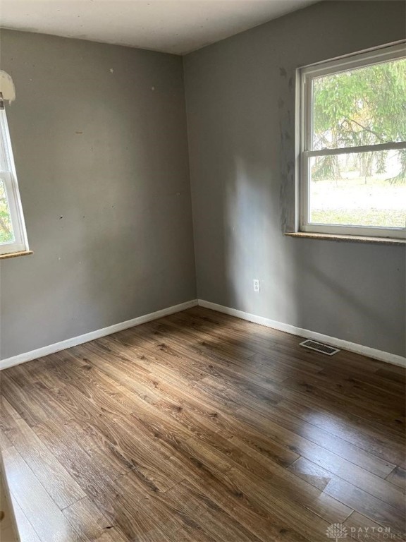 unfurnished room with a wealth of natural light and hardwood / wood-style floors