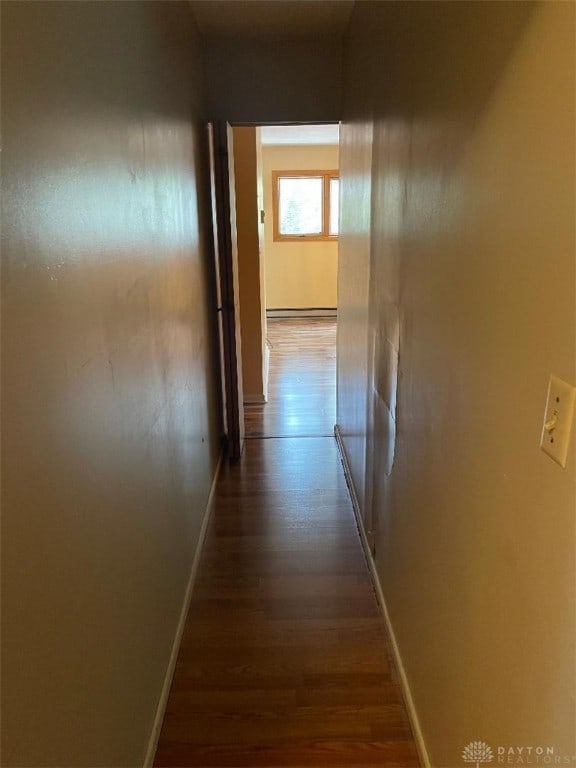 corridor with dark hardwood / wood-style floors and a baseboard radiator