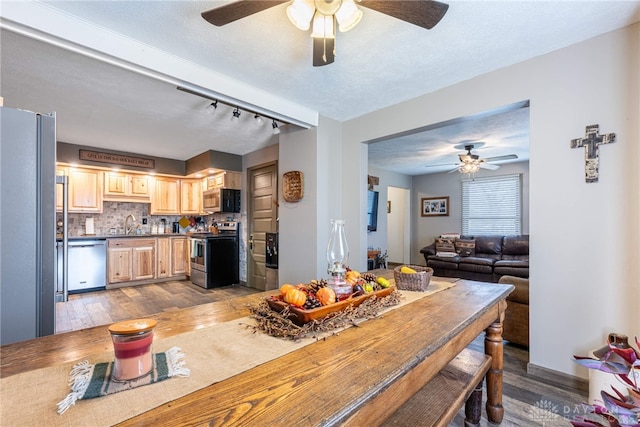 dining room with ceiling fan, hardwood / wood-style floors, rail lighting, and a textured ceiling