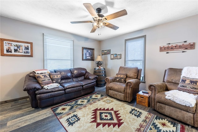 living room with a textured ceiling, dark hardwood / wood-style flooring, and ceiling fan