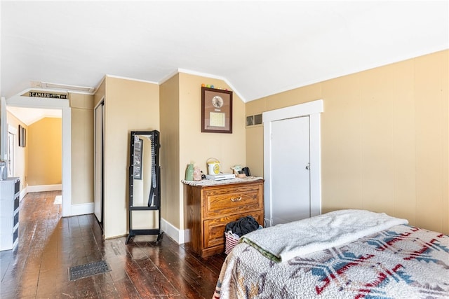 bedroom featuring vaulted ceiling, ornamental molding, and dark wood-type flooring