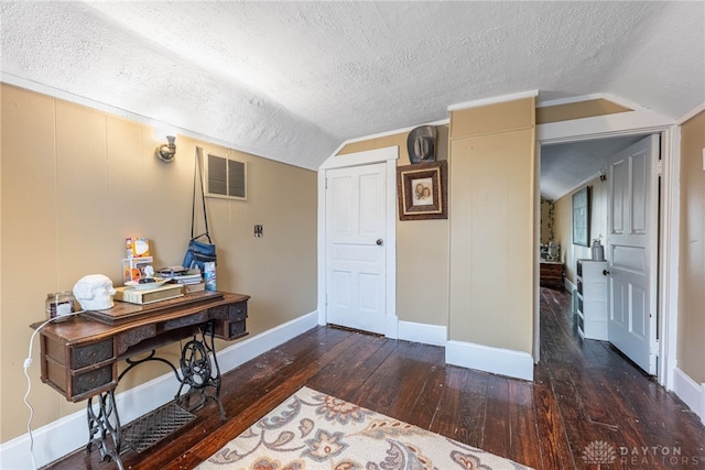 interior space featuring a textured ceiling, dark hardwood / wood-style flooring, and lofted ceiling